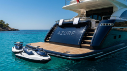 Azure yacht stern with jetskis in a turquoise bay