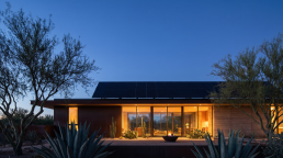 Desert modern home with solar panels glowing at blue hour