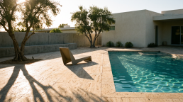 Minimalist backyard pool with travertine deck at golden hour