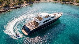 Aerial view of an Azure yacht and jetski anchored in a turquoise cove